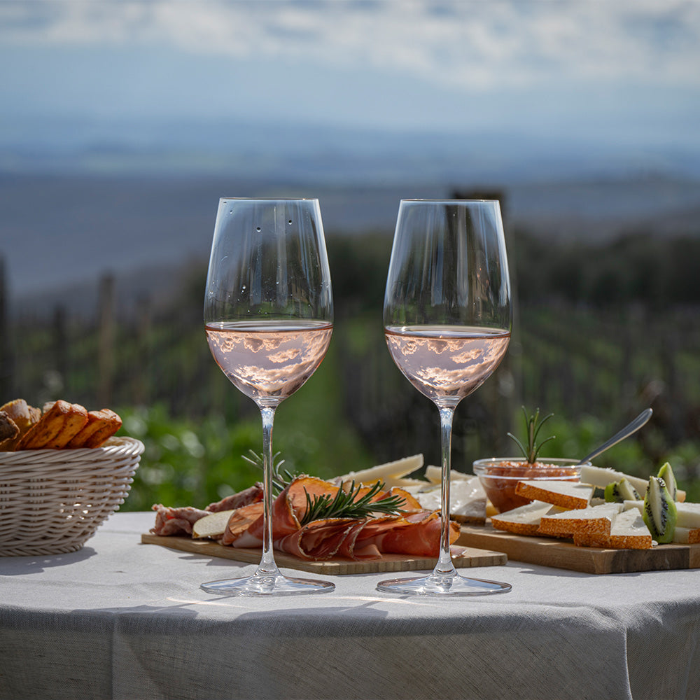 Two wine glasses with a scenic background